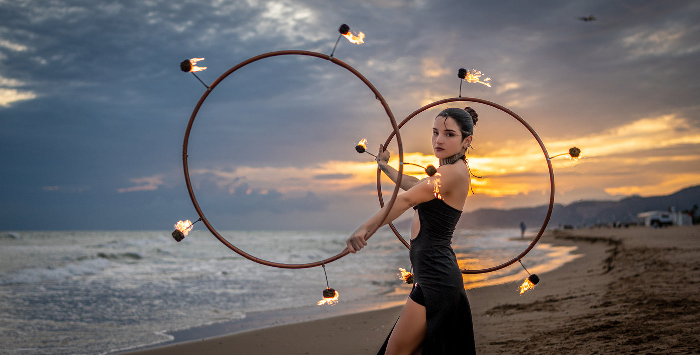 Spinsterz Ambassador Lucero Ponce performing with fire hoops at sunset