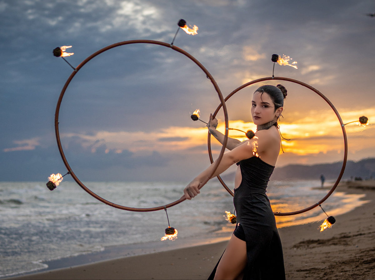 Spinsterz Ambassador Lucero Ponce performing with fire hoops at sunset