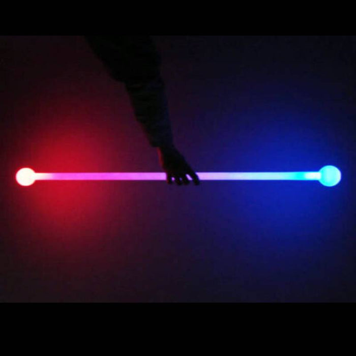 A person holding a LED glow staff that is lighting up in multiple colors including red and blue.